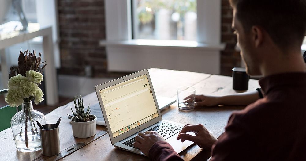 Man at a laptop in an office (Unsplash)